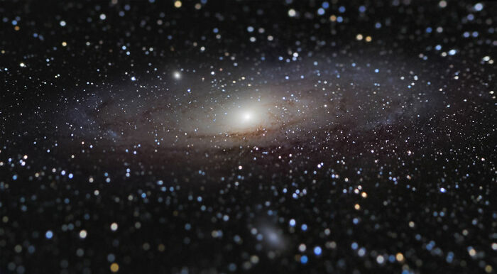 Distant galaxy surrounded by countless stars, showcasing the vastness of space.