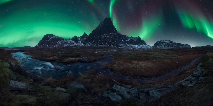 Stunning landscapes and starry skies with the Northern Lights over a rugged mountain and stream.