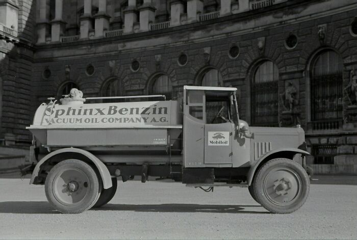 Historic Mobil fuel truck from the Vacuum Oil Company parked by an old building.