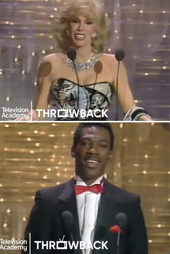 Two presenters at awards show, one in glamorous attire, the other in formal wear, captured in a throwback moment.