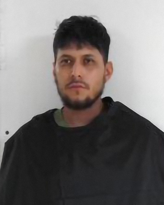 A concerned man standing against a plain background.