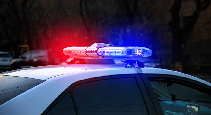 Police car with flashing lights responding to a call at night.