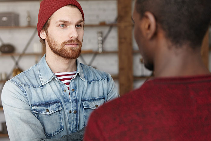 Two men in casual clothing discussing the importance of basic knowledge sharing.