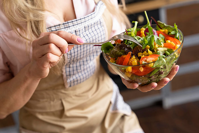 Person holding a fresh salad bowl, highlighting healthy eating as basic knowledge.