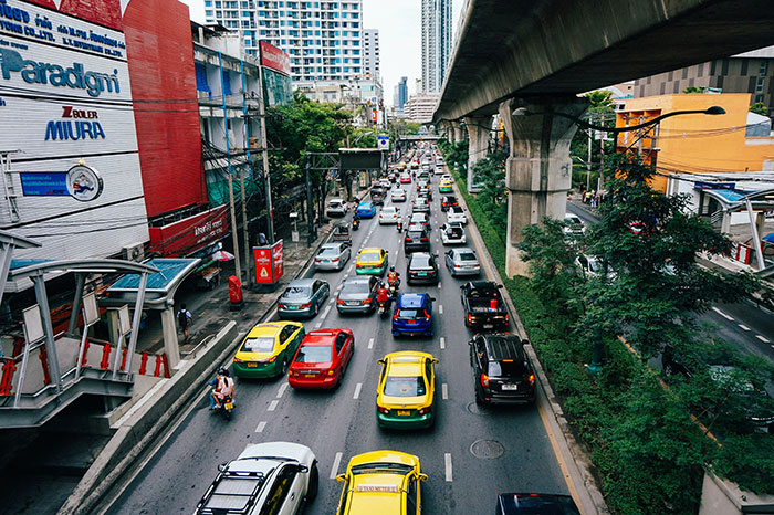Urban street scene with cars and motorcycles illustrating basic knowledge of transportation.