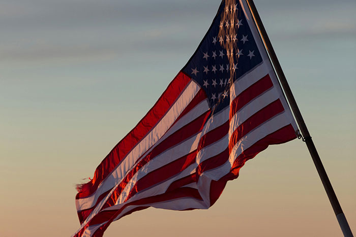 American flag waving at sunset, symbolizing basic knowledge of national symbols.
