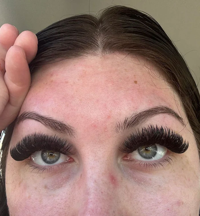 Close-up of eyes with noticeably large fake eyelashes, highlighting unnatural beauty trends.