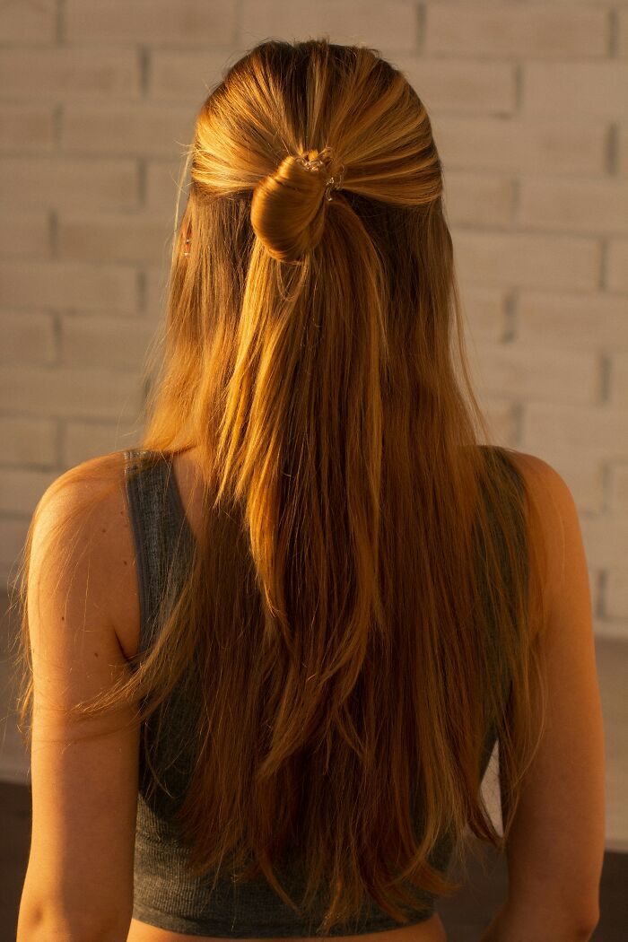 Blonde hair in a half-up bun style, representing natural beauty trends.
