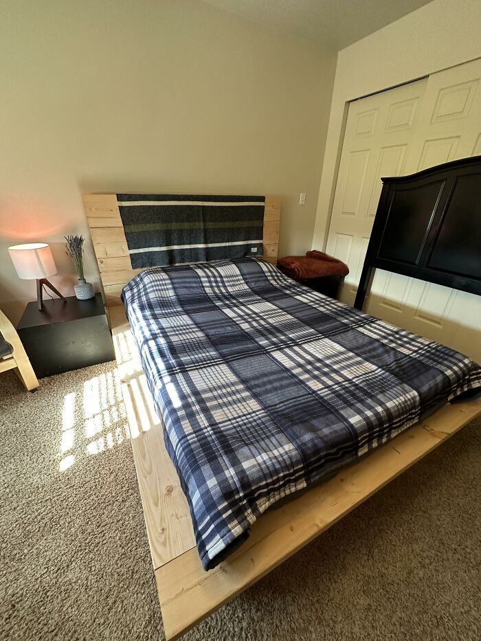 Bedroom with plaid bedding and wood furniture illustrating poorly-aging interior design trends to avoid.