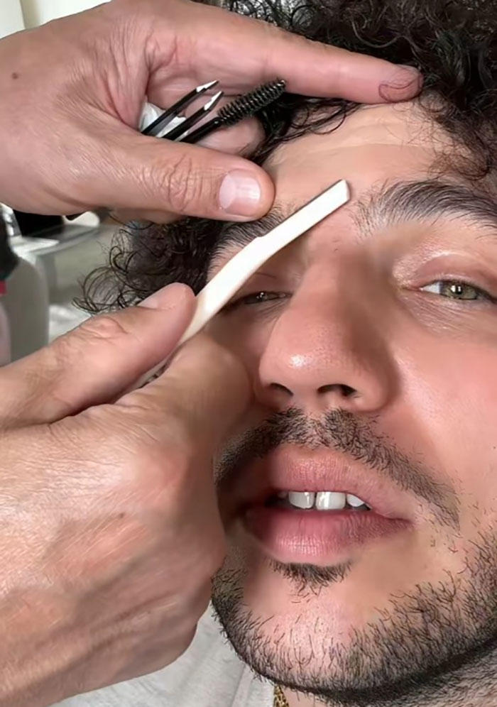 Person having eyebrows plucked, showing a transformation moment. Person having eyebrows plucked, showing a transformation moment.
