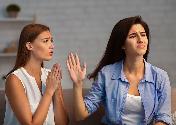 Two friends argue on a couch; one pleads, the other refuses to help with wedding planning. Two friends argue on a couch; one pleads, the other refuses to help with wedding planning.