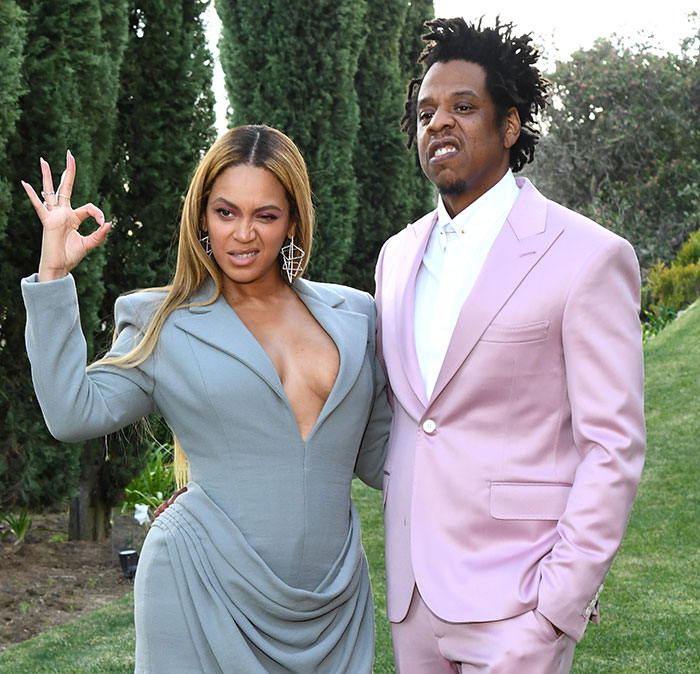 Beyonc&eacute; and Jay-Z posing outdoors in formal attire, reacting to a controversial statement.