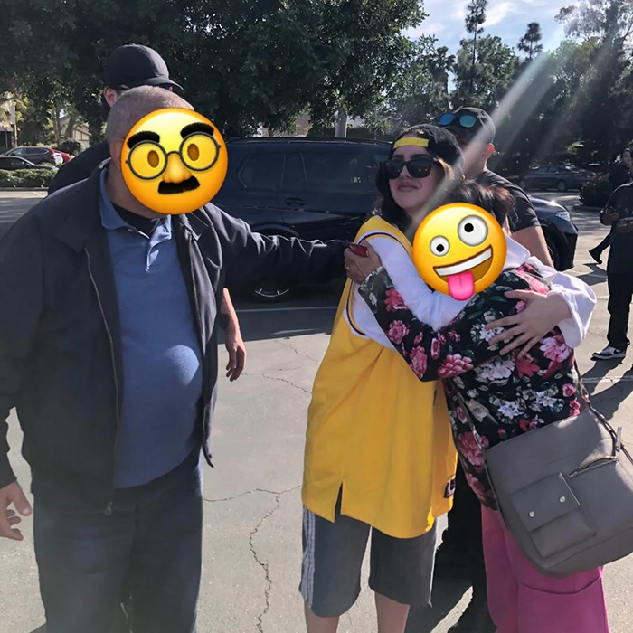 Billie Eilish look-alike in yellow jersey surrounded by fans, causing excitement at the mall.