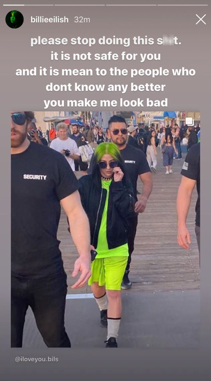 Billie Eilish look-alike in neon outfit causes chaos at a busy mall surrounded by security.