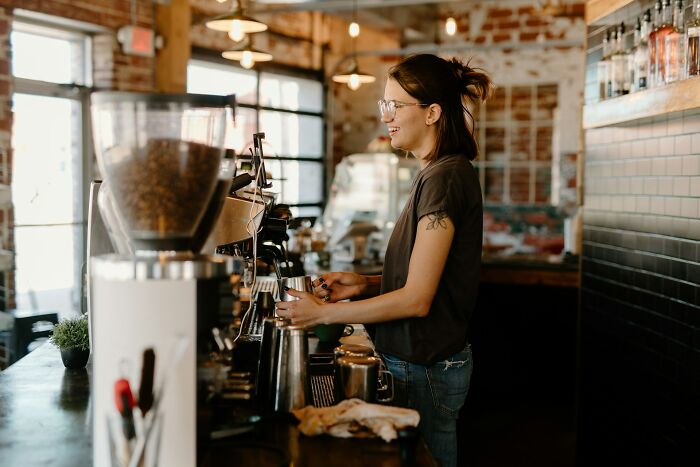 Barista preparing coffee in a cafe, representing stories of employees fired on the spot by bosses.