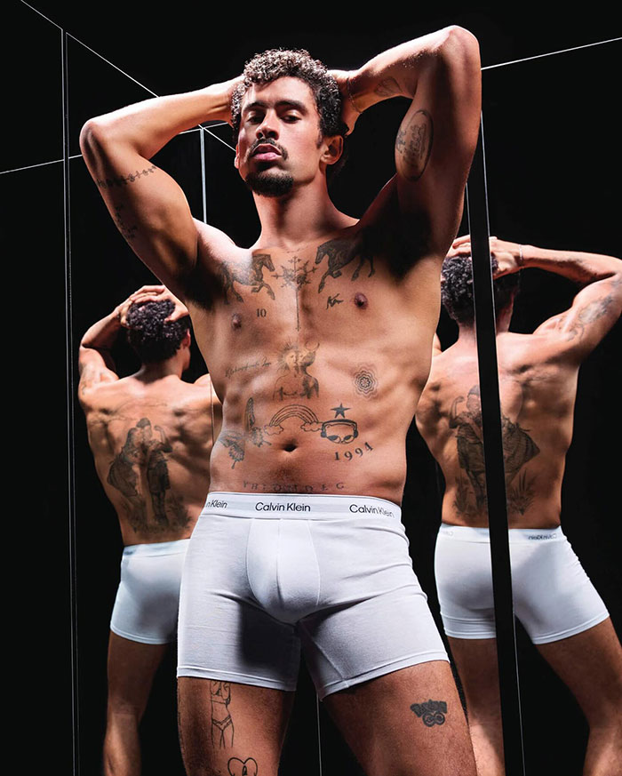 Model in Calvin Klein ad campaign, posing shirtless in white boxers, gaining viral attention.