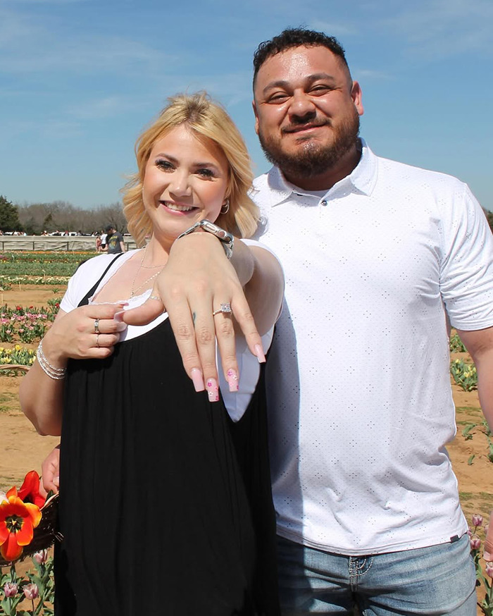 Bride-to-be showing her engagement ring with a man in a field, main SEO keyword: bride-to-be.