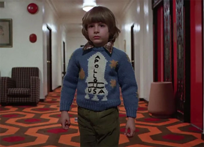 Child in a blue Apollo 11 sweater walking down a hotel hallway, reflecting on celebrities who disappeared from media.