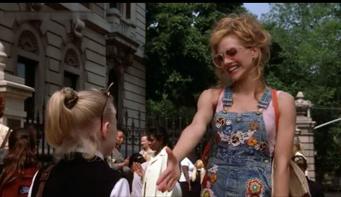 Smiling woman in patterned overalls greets a child outdoors, illustrating celebrities disappearing from media.