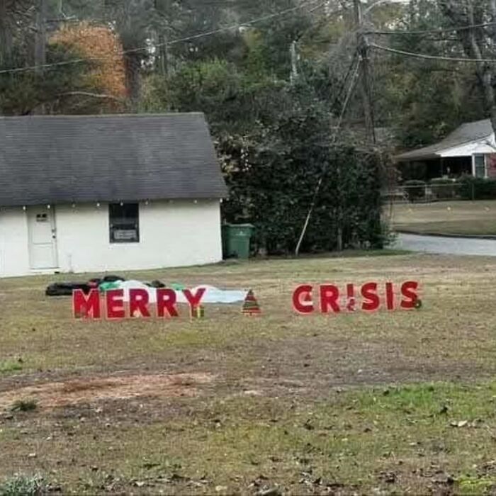 Lawn display with red letters spelling "Merry Crisis" in front of a house, depicting cheerful nihilism.