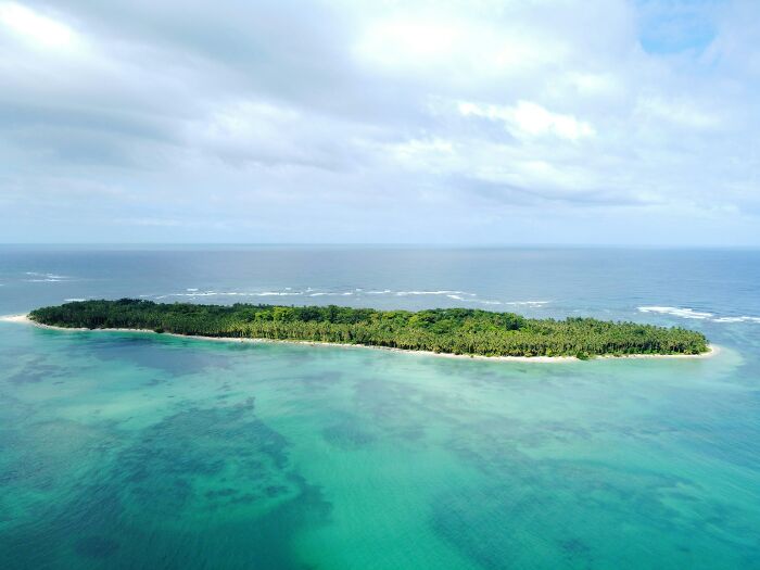 Aerial view of a stunning beach island surrounded by turquoise waters.