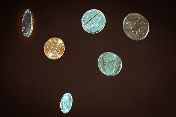 Floating coins against a dark background symbolizing overused office expressions.