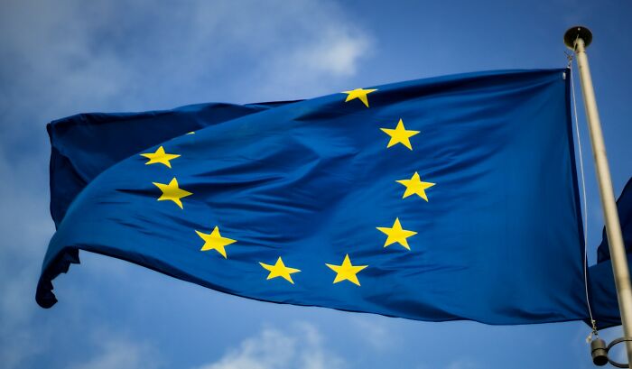 European Union flag waving against a clear blue sky.
