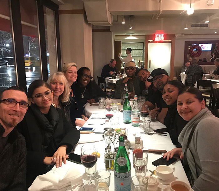 Group dining at a restaurant table, including people with drinks and food, related to Zendaya family rift and wedding.
