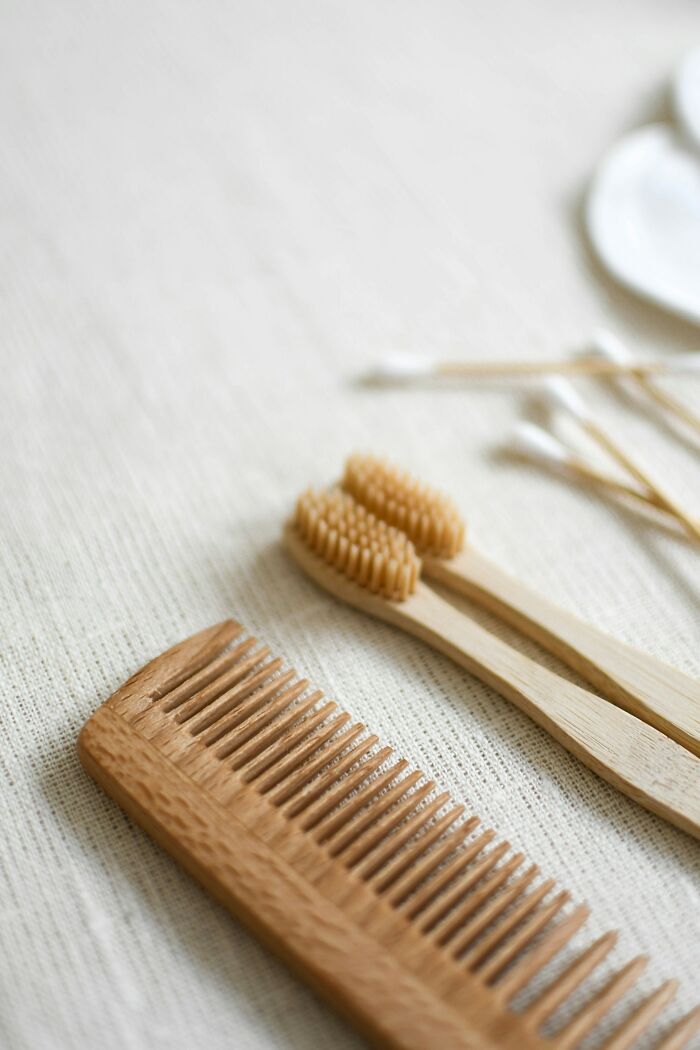 Wooden comb and toothbrushes on a textured surface, related to unusual items.