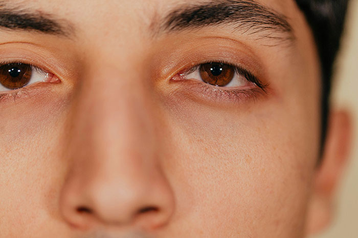 Close-up of a person's eyes and eyebrows, illustrating effective psychological tricks related to human perception.