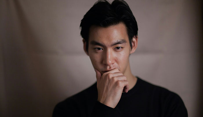 Man contemplating with hand on chin, illustrating psychological tricks in a pensive mood.