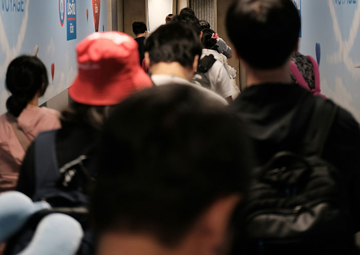 A crowded hallway with people walking, illustrating effective psychological tricks in social settings.