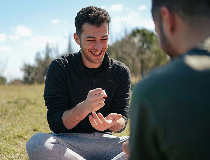 Two men playing rock-paper-scissors outdoors, demonstrating psychological tricks in social interactions.