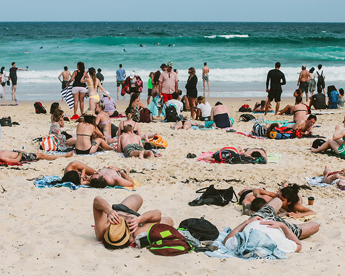 Beachgoers enjoying a sunny day at a crowded family swimming spot.