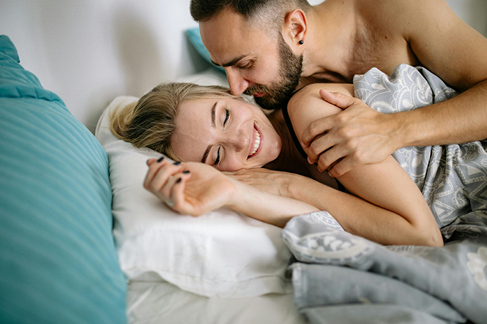 Couple cuddling in bed, illustrating relationship dynamics and perceptions of laziness. Couple cuddling in bed, illustrating relationship dynamics and perceptions of laziness.