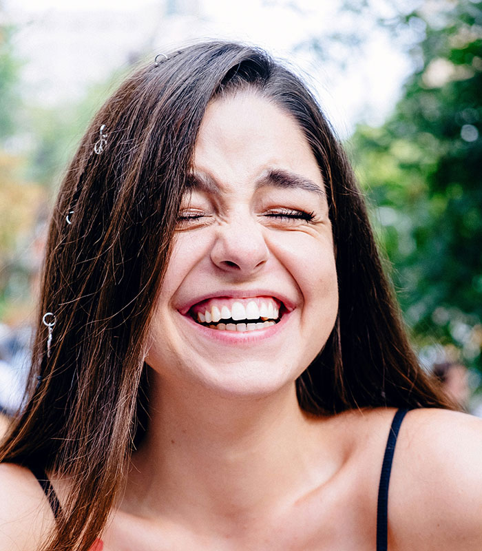 Smiling woman enjoying outdoor setting, highlighting unexpected cultural differences experienced by travelers.