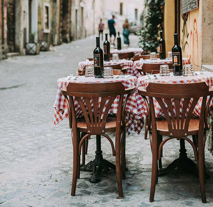 Outdoor café with checkered tablecloths and wine, reflecting unexpected cultural differences in dining.