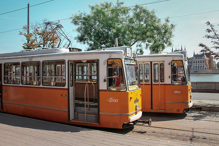Orange trams in a European city, highlighting unexpected cultural differences in public transportation.