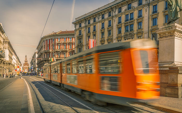 Orange tram in motion on a city street, highlighting unexpected cultural differences in urban transportation.