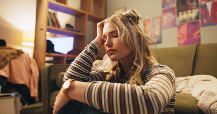 Young woman looking stressed in a room, dealing with family babysitting issues. Young woman looking stressed in a room, dealing with family babysitting issues.
