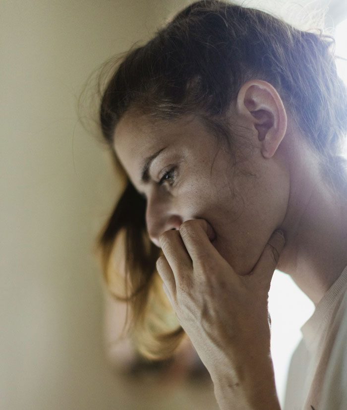 Woman in profile, deep in thought, representing shock and separation process emotions.