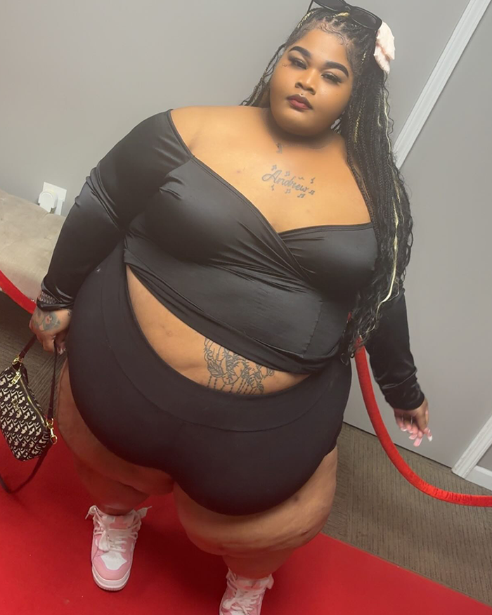 Plus-size rapper on red carpet in stylish black outfit and sneakers, showcasing confidence after viral photoshoot. Plus-size rapper on red carpet in stylish black outfit and sneakers, showcasing confidence after viral photoshoot.