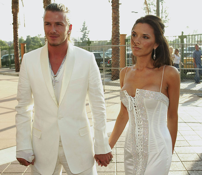 Man and woman in white outfits holding hands, related to Beckham's ex-assistant interview on affair.