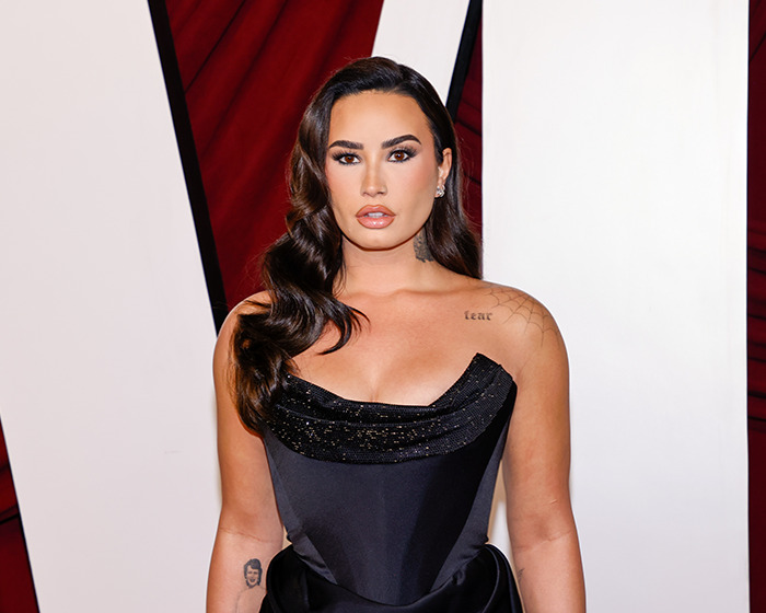 Woman in a sleek black dress, showcasing a stunning weight loss transformation, red carpet background.