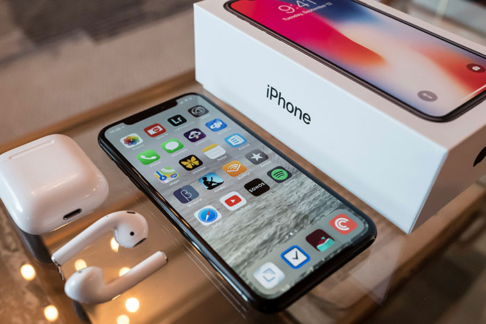 "iPhone with box and AirPods on a table, representing a brand concept."