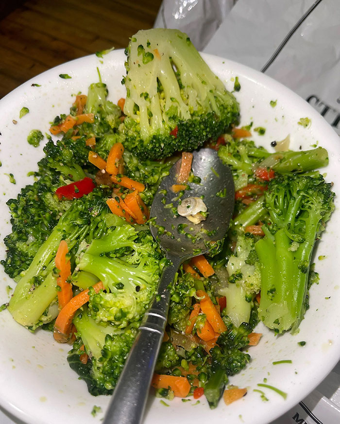Broccoli dish with a worm on the spoon, showing a surprising and disgusting food find.