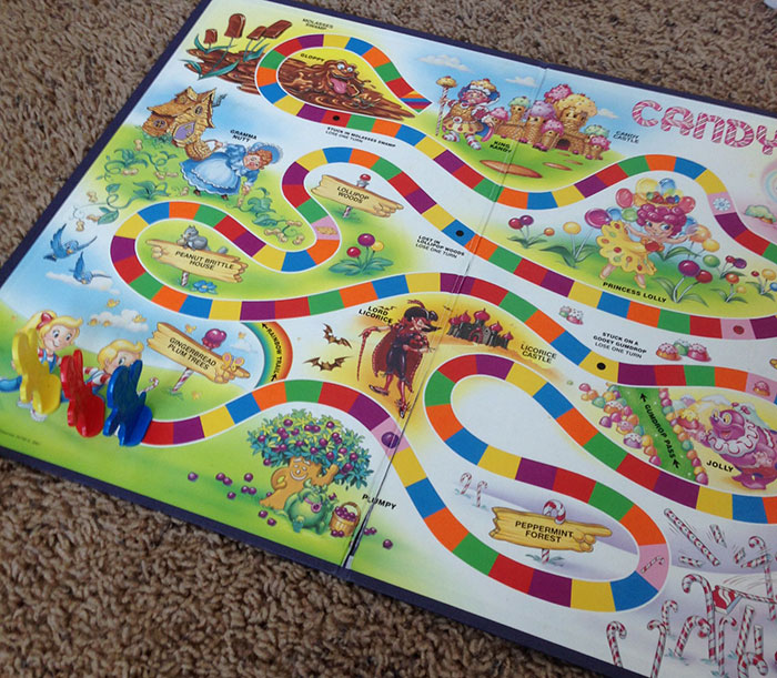 Colorful board game with characters on winding paths, resembling wholesome scenes but with disturbing backstories.