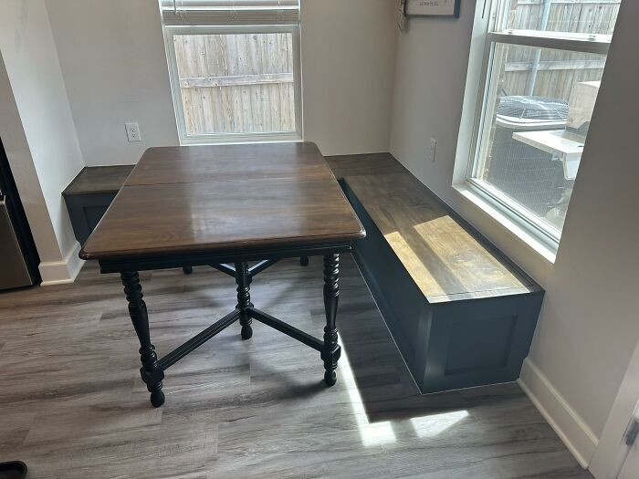 Wooden dining table with built-in bench seating in a bright room showcasing interior design trends to avoid.