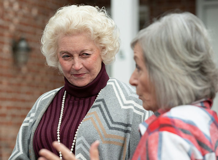 Two women engaged in conversation, illustrating unexpected family secrets revealed by DNA tests.