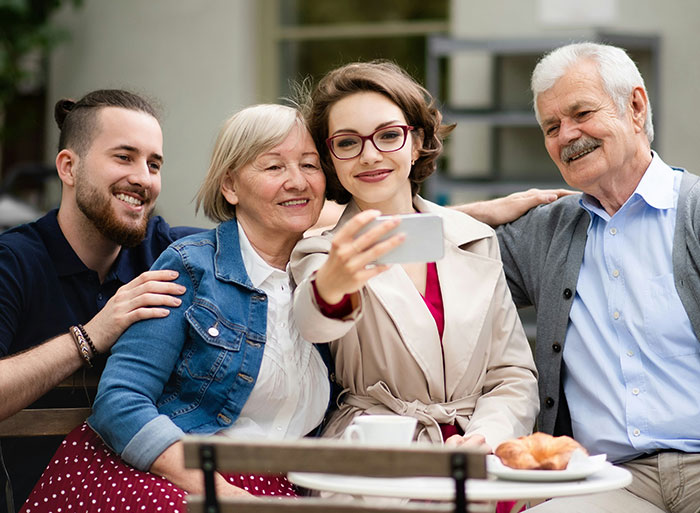 Family taking a selfie outdoors, showcasing bonds through an unexpected DNA test discovery.